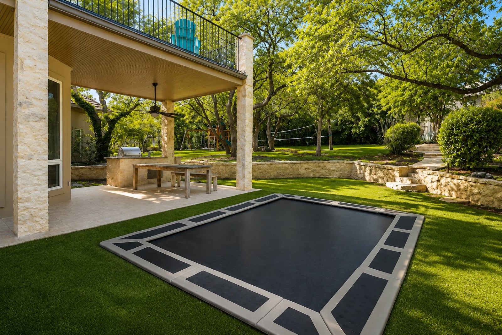 An in-ground trampoline set into an artificial-turf backyard
